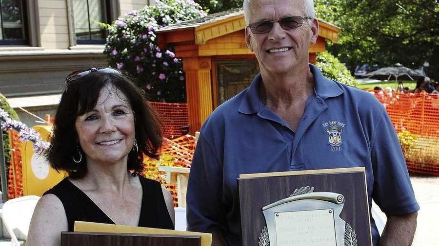 In this Sept. 6, 2014, photo, Ann Devlin, left, and Gordon Shepard, both of Saugus, Mass., hold up their Person of the Year awards during a Founder's Day celebration in Saugus, Mass. Devlin received the award for her efforts as an environmental activist in Saugus. Shepard received the award for his work helping to maintain the graves of fallen soldiers at the Riverside Cemetery in Saugus.