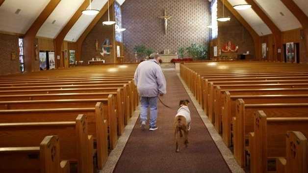 St. Frances Xavier Cabrini Church parishioner Heather Santosuosso of Scituate walks through the church Sunday, Feb. 8, 2015, with her dog Cabrini during Santosuosso's vigil shift.