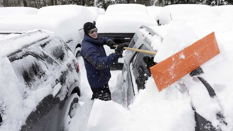 Lealand Welsh, of Wrentham, Mass., removes snow from cars and trucks at a Ford dealership, Sunday, Feb. 15, 2015, in Norwood, Mass. A storm brought a new round of wind-whipped snow to New England on Sunday, threatening white-out conditions in coastal areas and forcing people to contend with a fourth winter onslaught in less than a month.