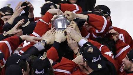 Boston University players reach for the Beanpot trophy after a win against Northeastern in the college hockey Beanpot Tournament's championship game in Boston.