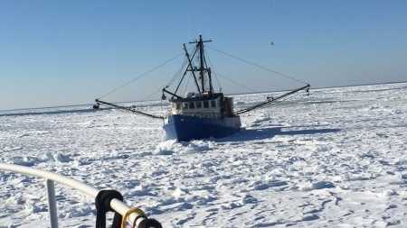 A Coast Guard aids to navigation team from Woods Hole, Mass., assists the fishing boat Capt. RM Chase in Woods Hole on Feb. 28, 2015. The fishing boat became lodged in ice on their way back to New Bedford, Mass., from a fishing trip.