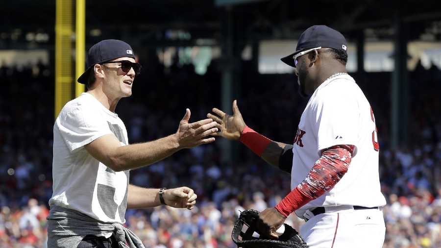 New England Patriots quarterback Tom Brady, left, greets Boston Red Sox's David Ortiz after throwing the ceremonial first pitch prior to the home opener baseball game between the Boston Red Sox and the Washington Nationals at Fenway Park in Boston, Monday, April 13, 2015. 