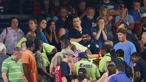 Rescue workers carry an injured fan from the stands at Turner Field during a baseball game between Atlanta Braves and New York Yankees, Saturday, Aug. 29, 2015, in Atlanta. The fan fell from the upper deck into the lower-level stands and was given emergency medical treatment before being taken to a hospital. 