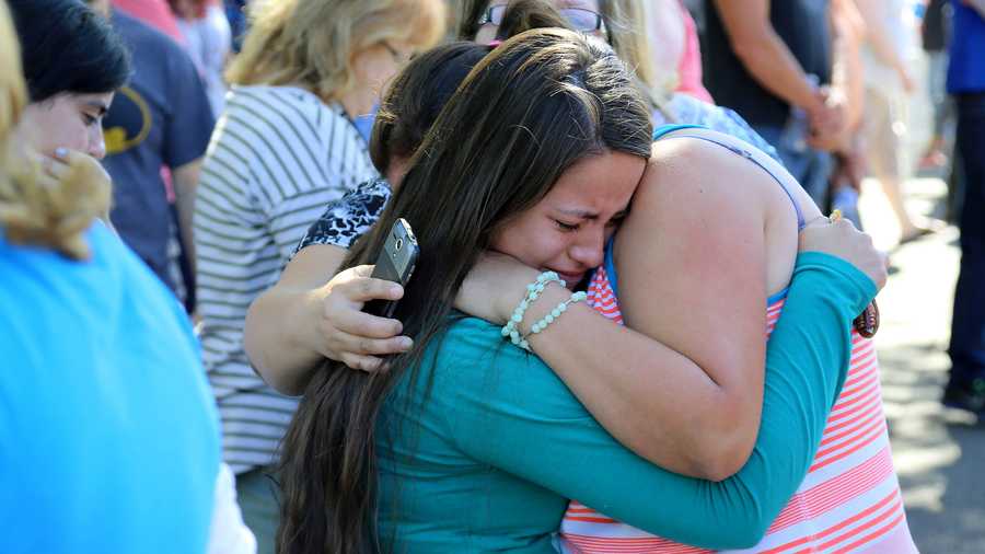 A woman is comforted as friends and family wait for students at the local fairgrounds after a shooting at Umpqua Community College in Roseburg, Ore., on Thursday, Oct. 1, 2015. (AP Photo/Ryan Kang)