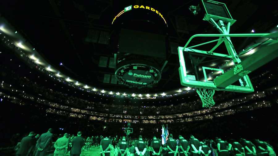 The house lights are shut off and scoreboard dark as the Boston Celtics pause for a moment of silence for the victims of shooting and bombing attacks in Paris prior to an NBA basketball game against the Atlanta Hawks in Boston, Friday, Nov. 13, 2015.