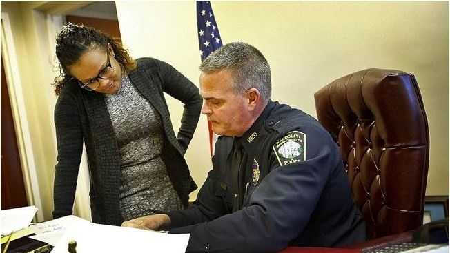 Employed by DOVE, Katheline Leconte is fluent in Haitian Creole and works inside local police departments. She is seen here with Randolph Police Chief William Pace.