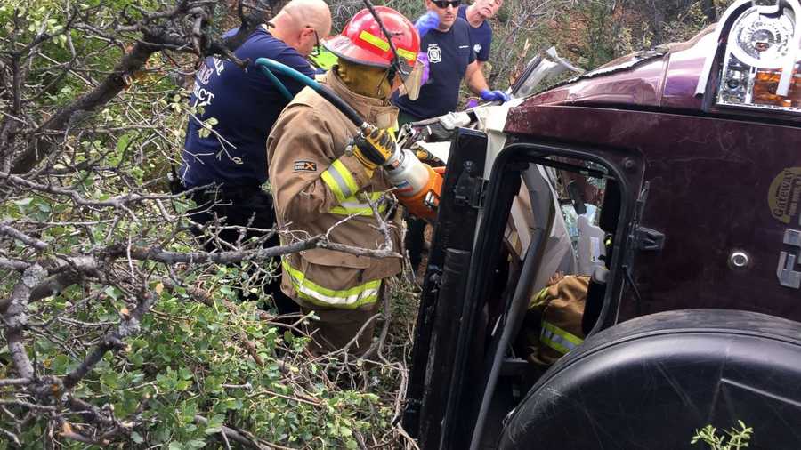 This photo provided by Kim Moore shows firefighters working to extricate a 50-year-old man from his crashed car on Mingus Mountain in Yavapai County, Arizona on Friday, May 27, 2016. Authorities say a man trapped in his crashed vehicle on a central Arizona mountain for three days was rescued thanks to a couple taking sightseeing photos. 