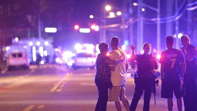 Orlando Police officers direct family members away from a fatal mass shooting at Pulse Orlando nightclub in Orlando, Fla., Sunday, June 12, 2016. 