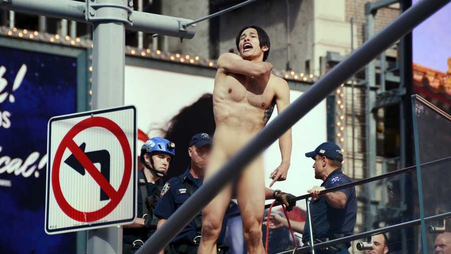 A naked man shouts before jumping from the ledge above the TKTS Broadway ticket booth in New York's Times Square, Thursday, June 30, 2016. Police said the man, who was shouting about presumptive Republican presidential nominee Donald Trump, was conscious after the jump of about 16 feet off the booth.