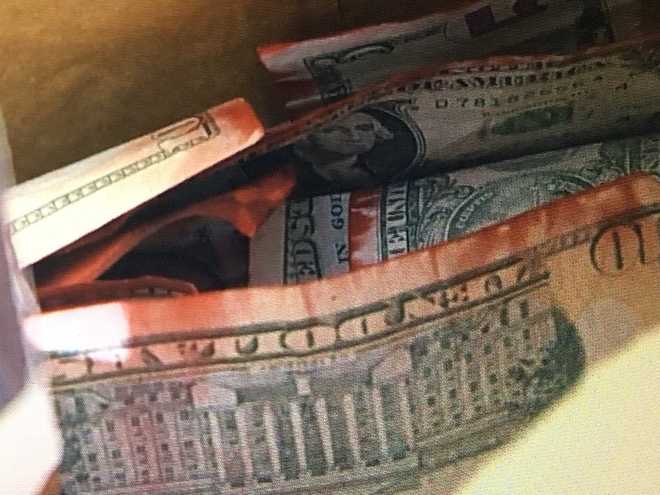 Masked bank robber drops cash after dye pack bursts