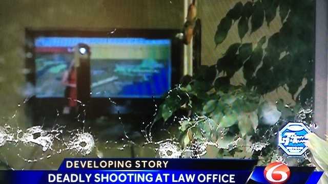 A bullet-riddled door shows some of the dozens of gunshots fired into a Covington law office.