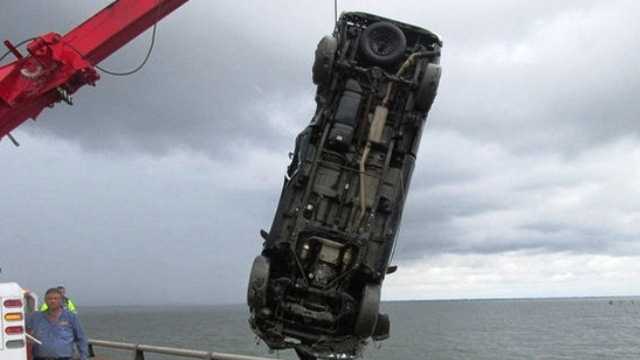 A vehicle is removed from Lake Pontchartrain after crashing over the protective railing on the Causeway on May 31, 2014