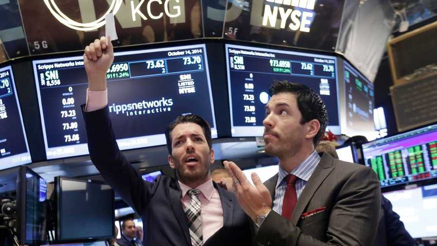 In this Oct. 14, 2014, file photo, Jonathan Scott, left, and Drew Scott, of HGTV's "Property Brothers" cable television show, mimic traders on the floor of the New York Stock Exchange.AP Photo/Richard Drew, File