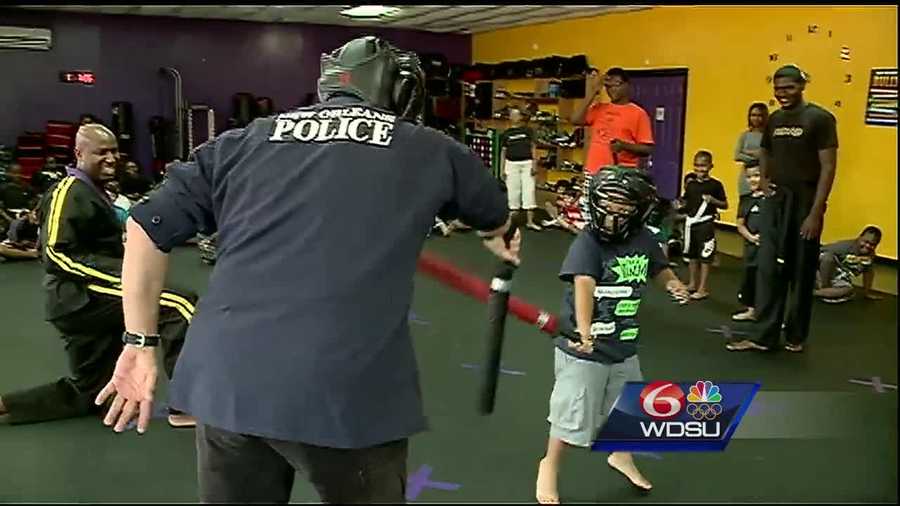 New Orleans police officers take time out to "kick it" with children in an effort to "cut" crime.