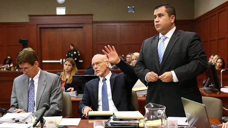 George Zimmerman, with his attorneys, Mark O'Mara (left), and Don West, stands to be identified by state witness Chris Serino, a Sanford police officer, during his testimony in Zimmerman's trial in Seminole circuit court, in Sanford, Fla., Monday, July 1, 2013. West is signaling to the witness that his client will stand to be identified. (Joe Burbank/Orlando Sentinel/POOL)