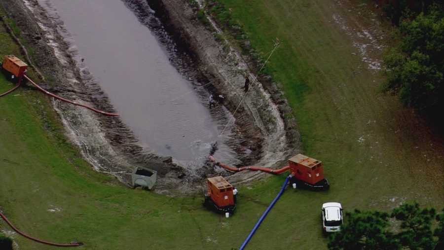 Orange County Public Works officials drained a pond near the shed where three homeless people were found shot to death last week.