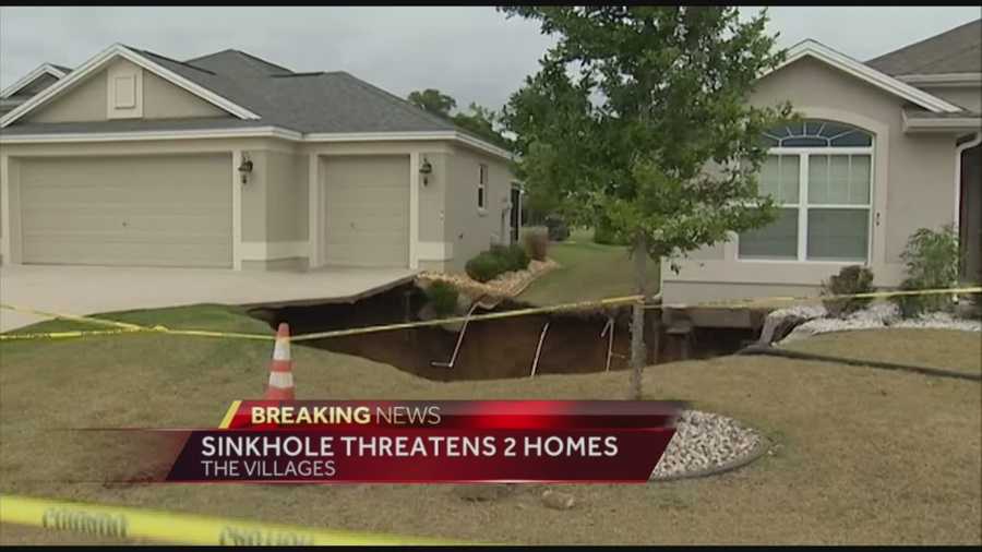 Two homes in the Sumter County section of The Villages are threatened by a sinkhole that grew in size as crews were trying to fill it Saturday.