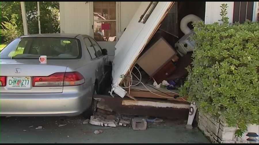 A car slammed into a mobile home early Monday morning, briefly trapping a woman in her bed and sending furniture and debris everywhere.