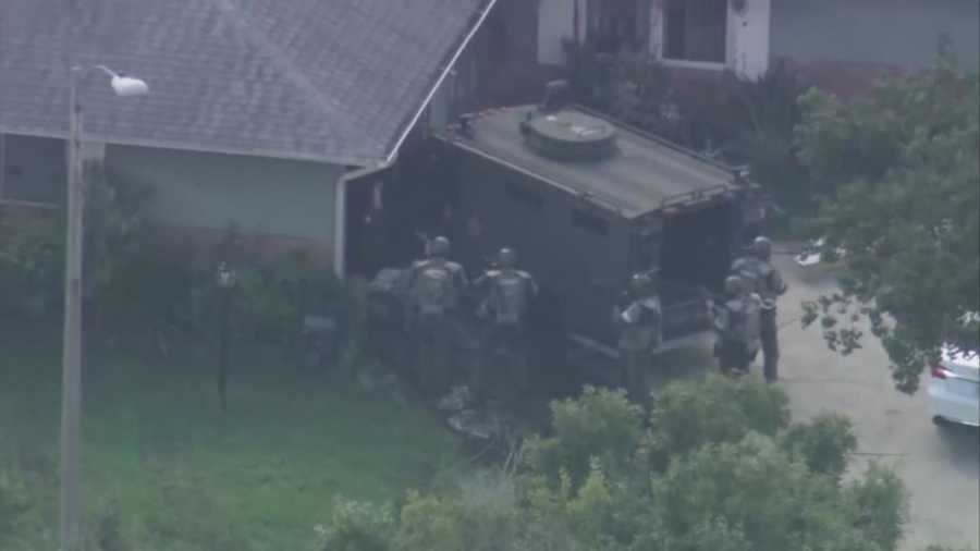 A man wanted on murder charges barricaded himself inside an east Orange County home for more than 10 hours Friday, officials said.
