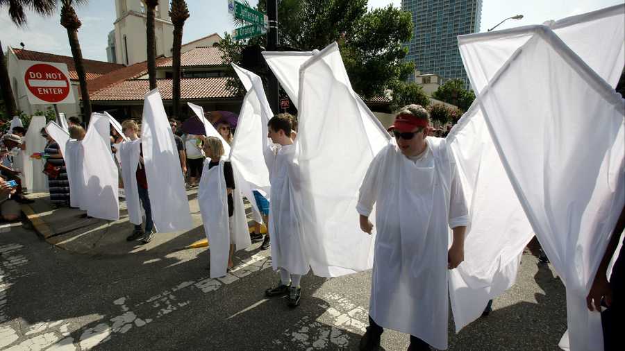 Counter demonstrators dressed as angels to show support and solidarity block the view of protesters near the funeral service for Christopher Andrew Leinonen, one of the victims of the Pulse nightclub mass shooting, outside the Cathedral Church of St. Luke, Saturday, June 18, 2016, in Orlando, Fla.