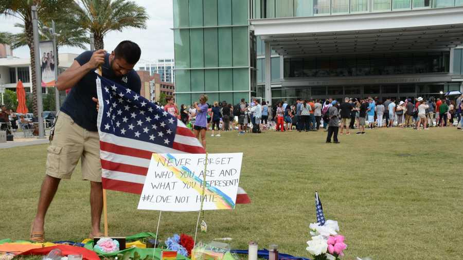 Jose Luis Nevarez secures an American flag into the ground near the memorial for those killed in the Orlando shooting.Nevarez grew up in Orlando and went to high school with one of the victims who was killed.