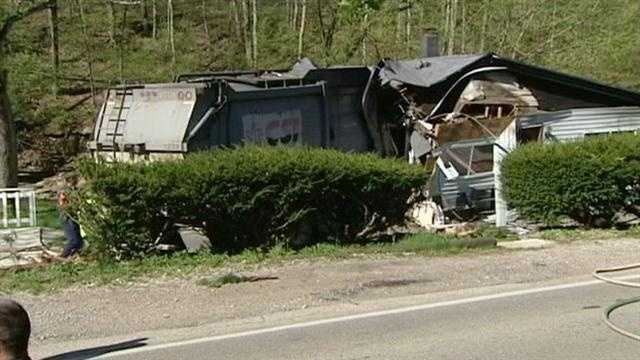 A woman escaped with cuts and scrapes when a garbage truck trashed her home Monday morning.