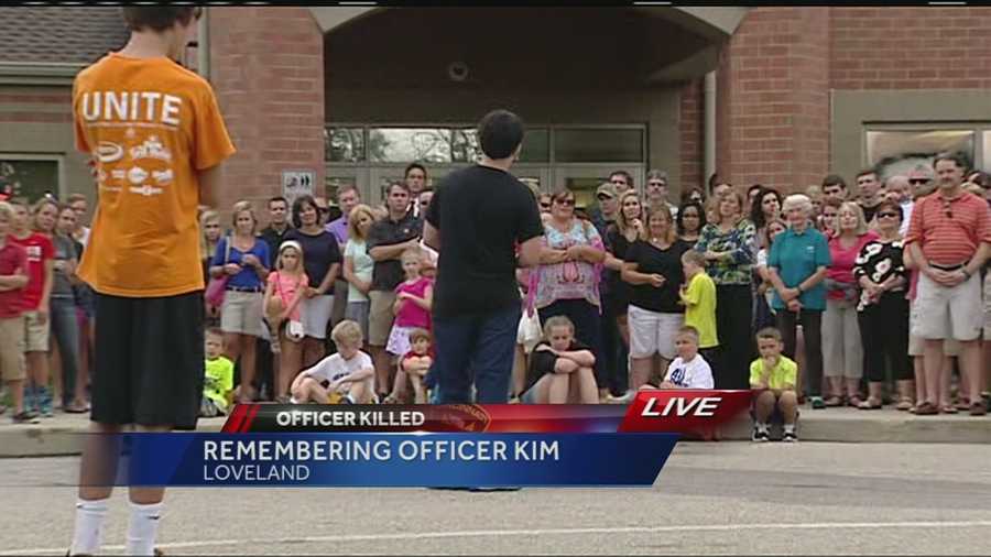 copy - Mourners hold vigil for Officer Sonny Kim in Loveland Saturday, June 20, 2015: Mourners hold a vigil for Kim outside Loveland Middle School.Watch this story