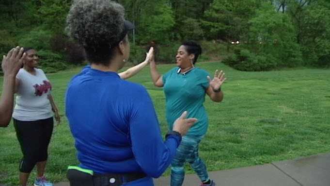 A woman in Black Girls Run Cincinnati, an organization aimed at battling obesity in the black community, finishes her run to high-fives from other club members. The group will participate in the 2016 Flying Pig.