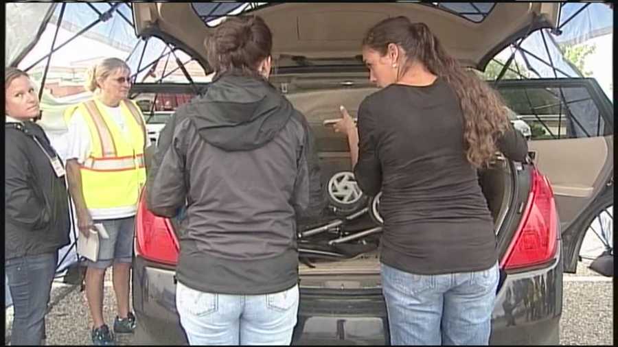 Law enforcement officials help parents learn the correct ways to install children's car seats into vehicles.