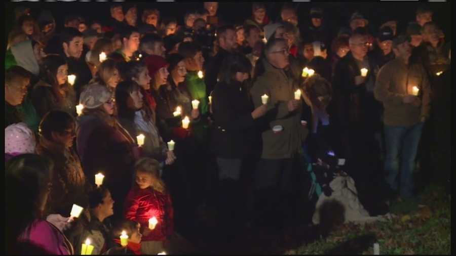 Candles lit up a cold November night as friends, family and neighbors gathered to mourn the deaths of the three victims of Wednesday's triple homicide.
