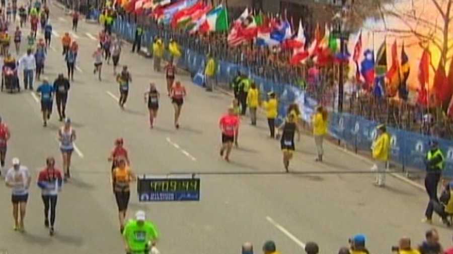 A bomb explodes at the finish line of the Boston Marathon. You can see a fireball at the top-right corner of the photo.