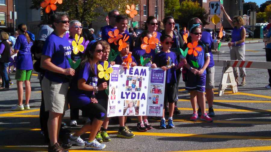 Granite Staters pose for a picture, showing for whom they are walking in Saturday's Walk to End Alzheimer's.