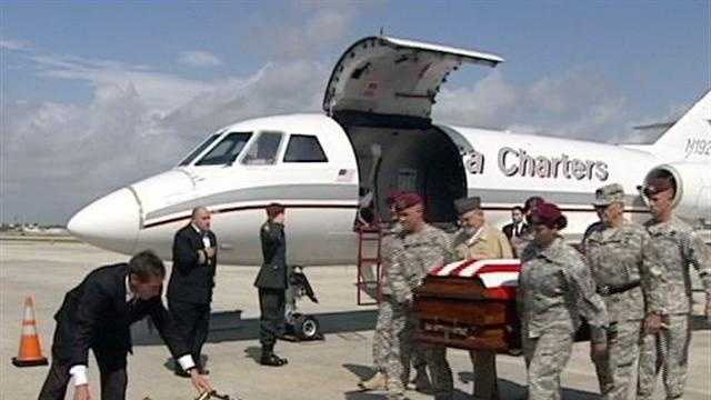 A casket carrying the body of Army soldier Michael Metcalf arrives at Palm Beach International Airport.