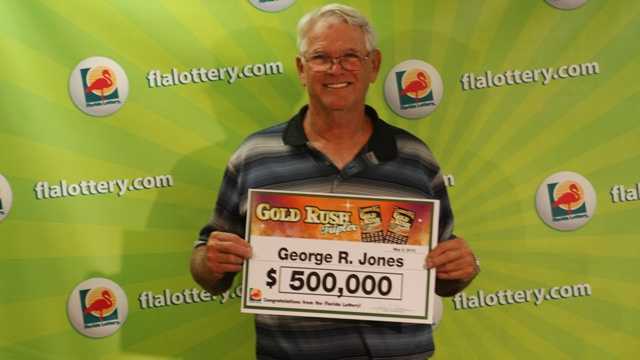 George Jones poses with the $500,000 check he received for winning the Florida Lottery Gold Rush Tripler scratch-off game.
