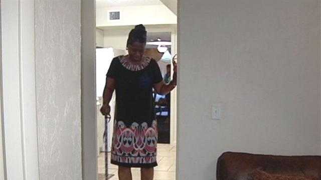 Rosa Wright walks with a cane through her new house, purchased courtesy of the Rev. Griffin Davis Sr.