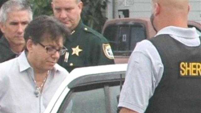 Dr. Bruce Kammerman is led out of the Stuart Pain Management clinic in handcuffs.