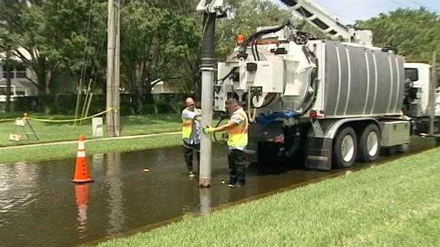 West Palm Beach employees use a truck to vacuum the floodwater and dispose of it in drains.