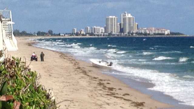Three people were taken into custody after a small boat washed ashore near Palm Beach on Monday. (Photo: Ted White/WPBF)