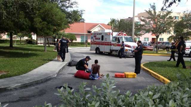 Paramedics treat a shooting victim at the Palm Grove Apartments.