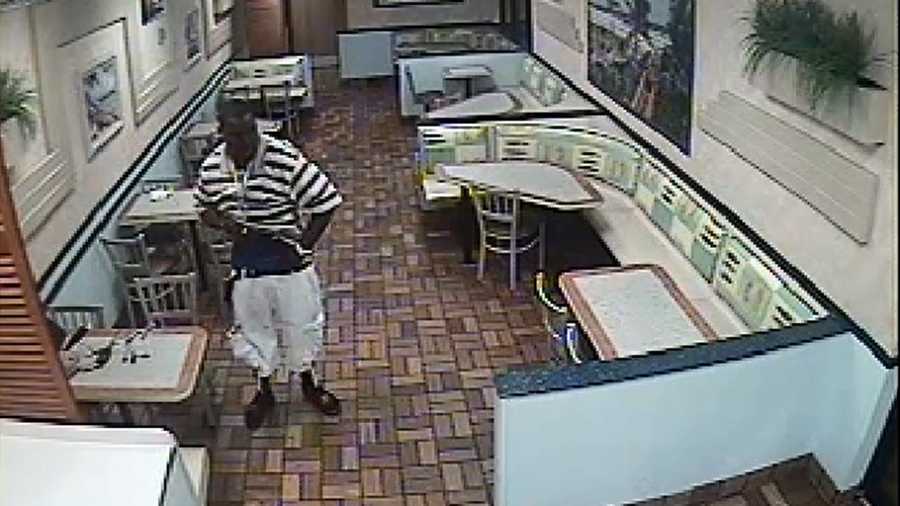 Surveillance video shows this man stuffing a laptop in his shorts.