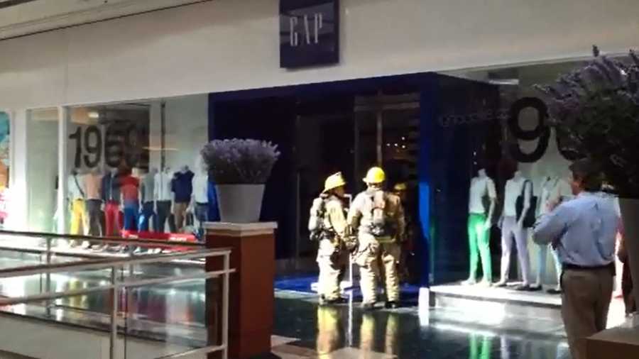 Firefighters inspect an overheated air-conditioning unit at the Gap inside the Gardens Mall.