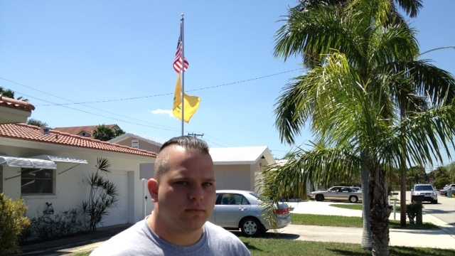 U.S. Marine veteran Gregory Schaffer proudly stands in front of the flagpole in his front yard.