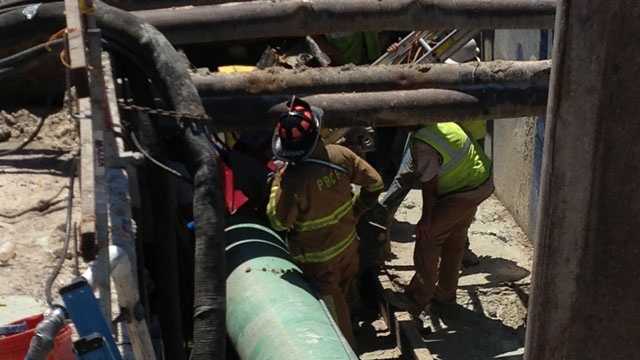 Rescuers help a worker who was injured at a construction site near Seminole Pratt Whitney Road and Beeline Highway.