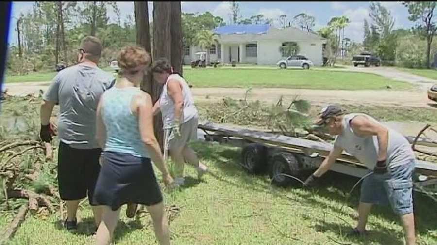 Neighbors, strangers and co-workers help cleanup debris after Thursday's tornado in Loxahatchee.