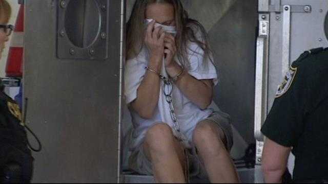 Georgia Scordamaglia covers her face as she led into the St. Lucie County Jail.