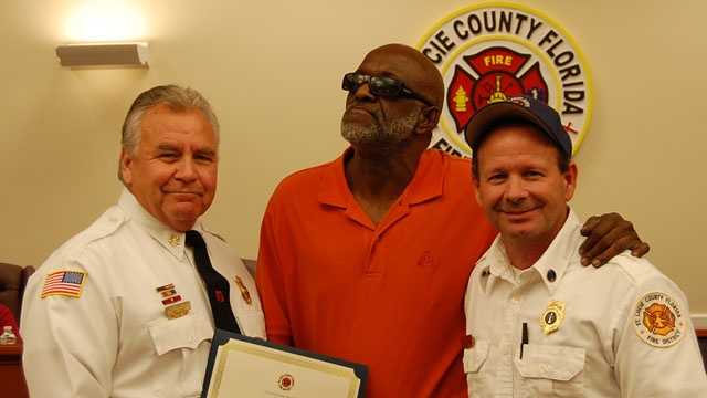St. Lucie County Fire District Chief Ron Parrish and Lt. Tommy Neiman present Tommy Barber (center) with the Citizen Hero Award.