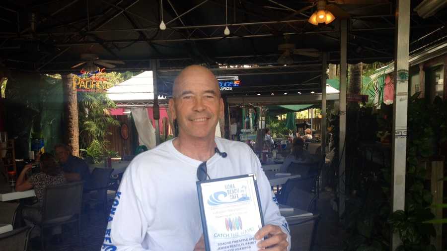 Frank Wacha displays his menu for this weekend's event in which he'll be serving shark to commemorate the two-year anniversary of his brush with a shark.