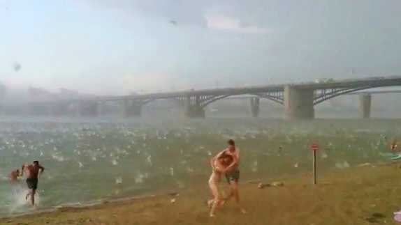 Sudden freak hail storm in Siberia causes beach goers to run for safety. 