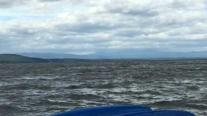 Coast Guard rescuers helped save three people in the water after their vessel overturned Wednesday on Lake Champlain, Vermont.