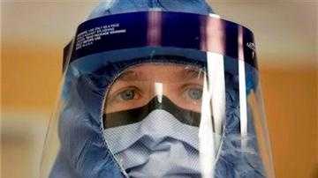 (AP Photo/Charles Rex Arbogast, File). FILE - In this Oct. 16, 2014, file photo, Registered nurse Keene Roadman, stands fully dressed in personal protective equipment during a training class at the Rush University Medical Center, in Chicago.